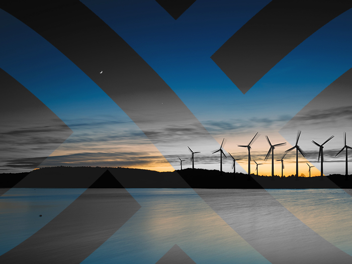 Off-shore wind farm in the distance. Black and white seascape with GridBeyond Motif highlighting areas in colour. Energy expert feature image.